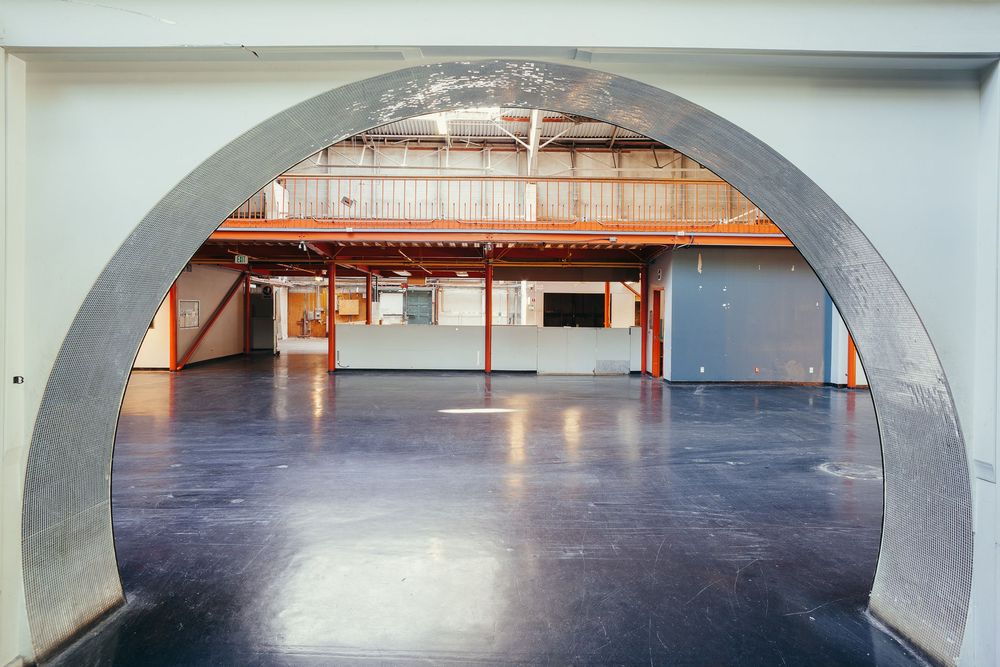 Arched entryway leading into a spacious room with polished concrete flooring.