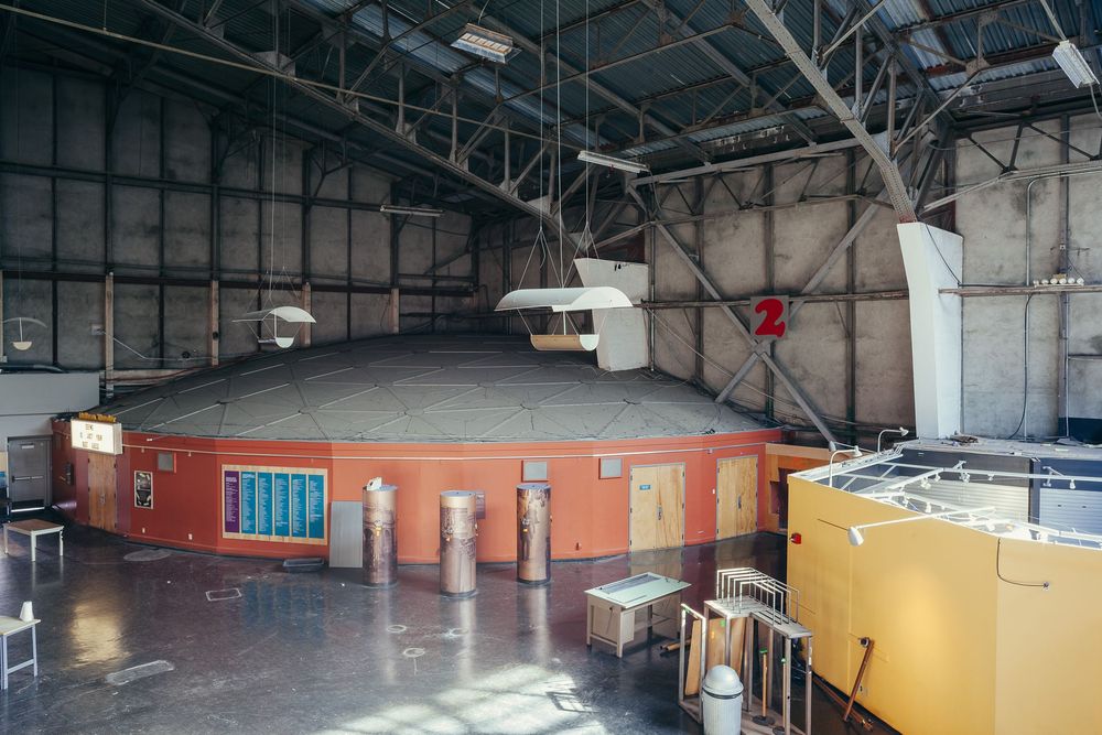 Industrial space with exposed ceiling infrastructure and minimal interior finishing.