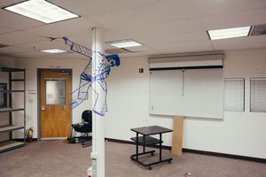 Clean white room with fluorescent lighting and air conditioning unit mounted on wall.