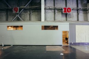 Industrial hallway with numbered sections and small viewing windows.