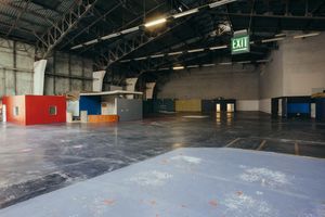 Large empty warehouse space with colored walls and exposed ceiling.