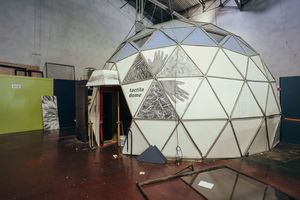 Large geodesic dome structure inside industrial space.