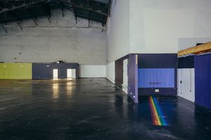 Dark industrial space with polished concrete floors and dramatic lighting effects.