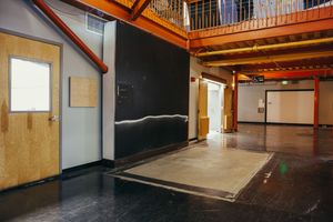 Industrial loft space with wooden beams and mezzanine level visible.