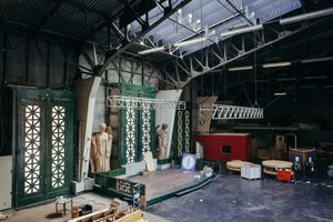 Wide angle view of an industrial warehouse space with exposed steel trusses and natural lighting.