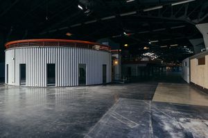 Expansive empty warehouse floor with concrete surfaces and overhead lighting.