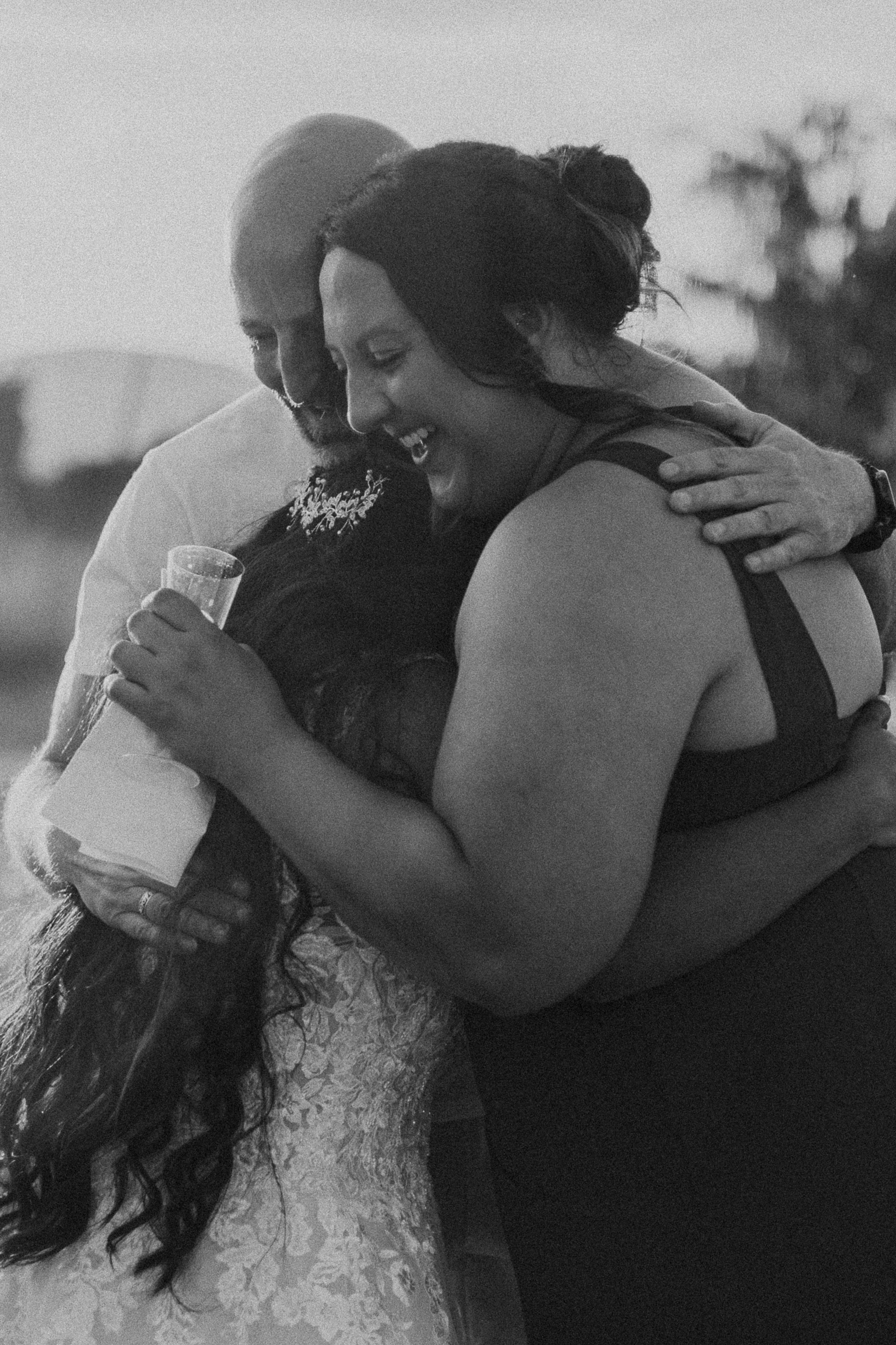 Black and white series of emotional embraces between wedding guests.