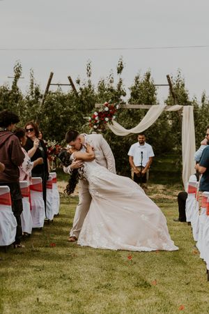 Wedding ceremony sequence showing couple's first kiss under outdoor arch.