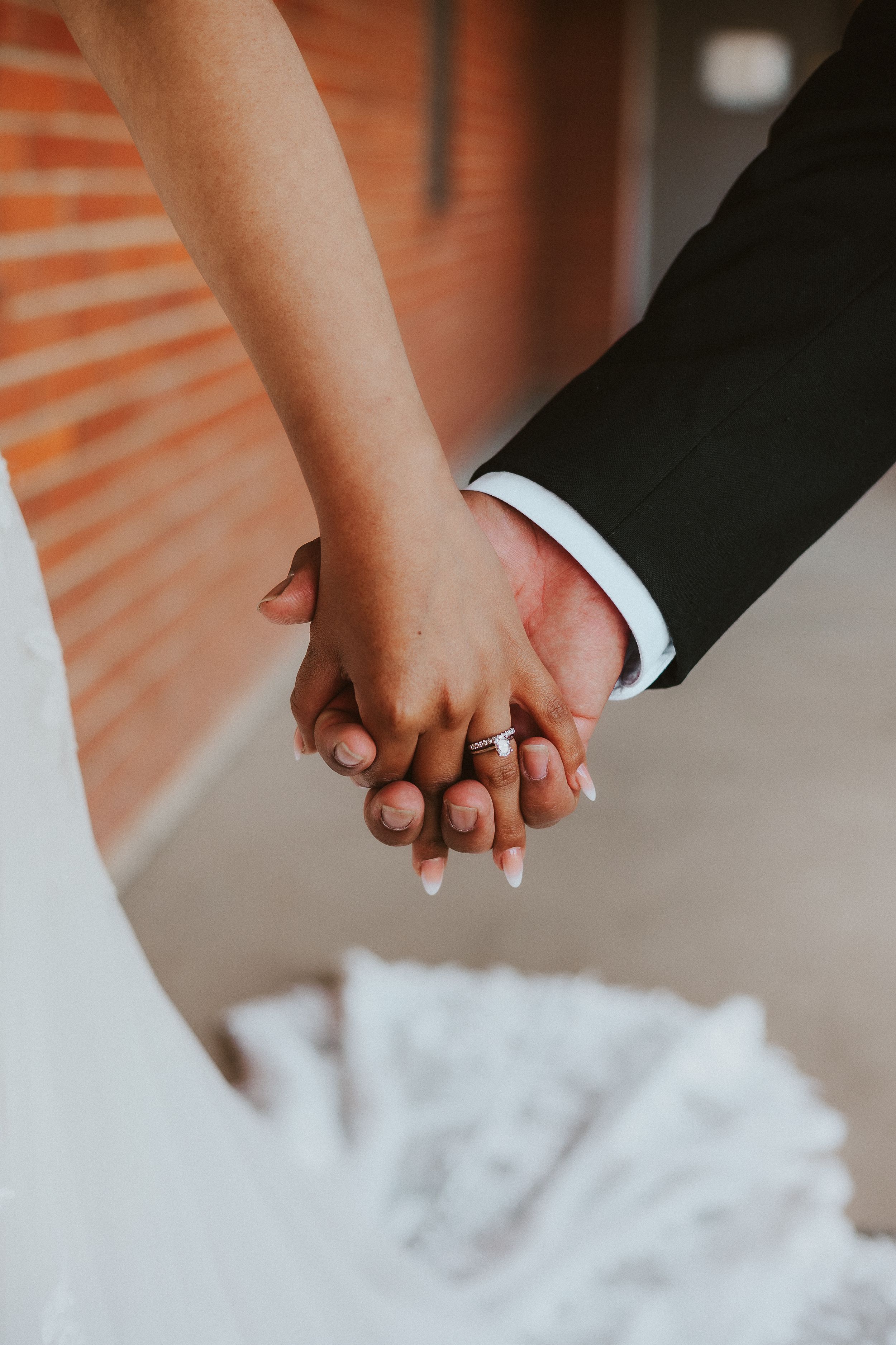 Close-up of hands touching against white fabric background.
