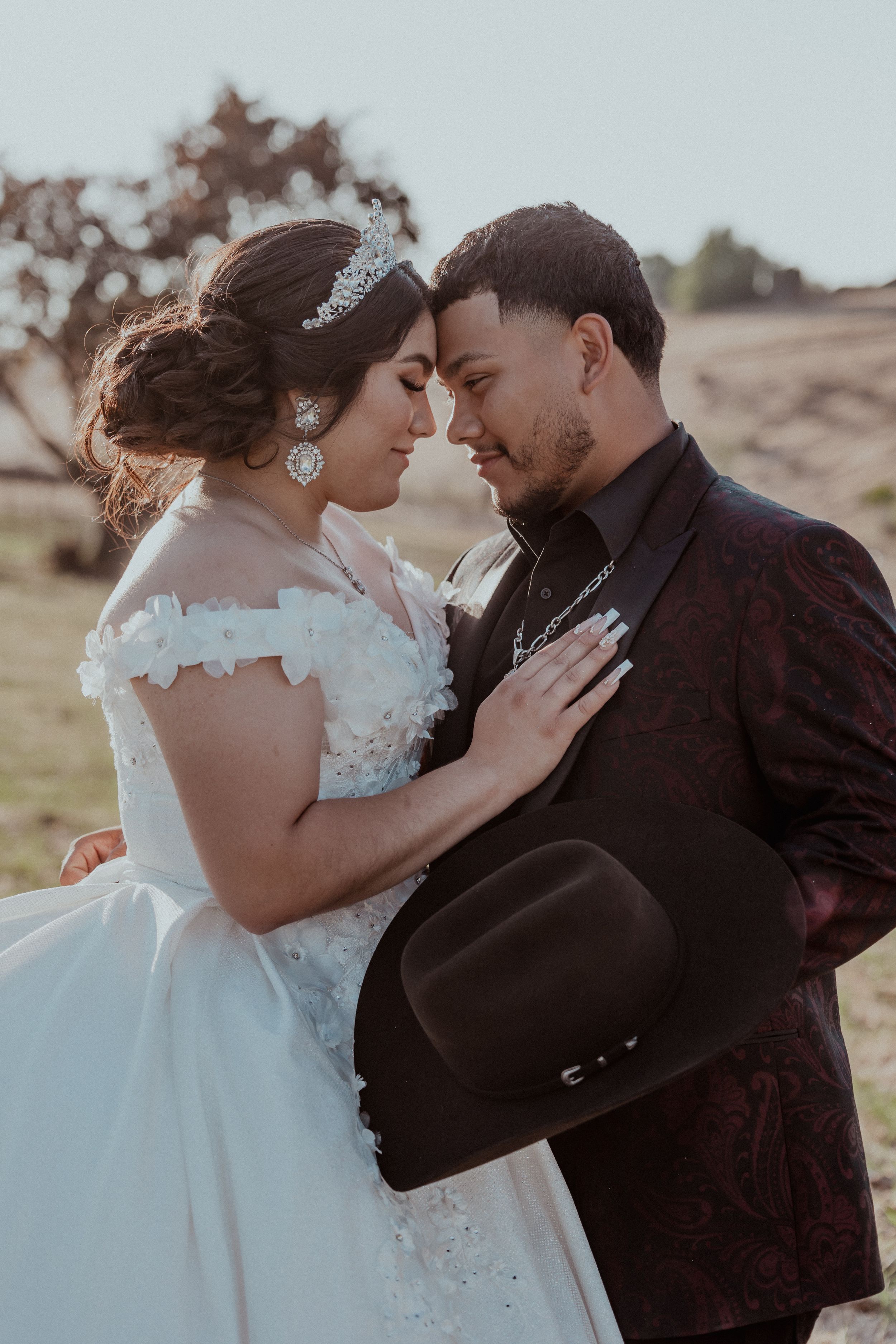 An intimate wedding portrait of a couple sharing a tender moment at sunset.