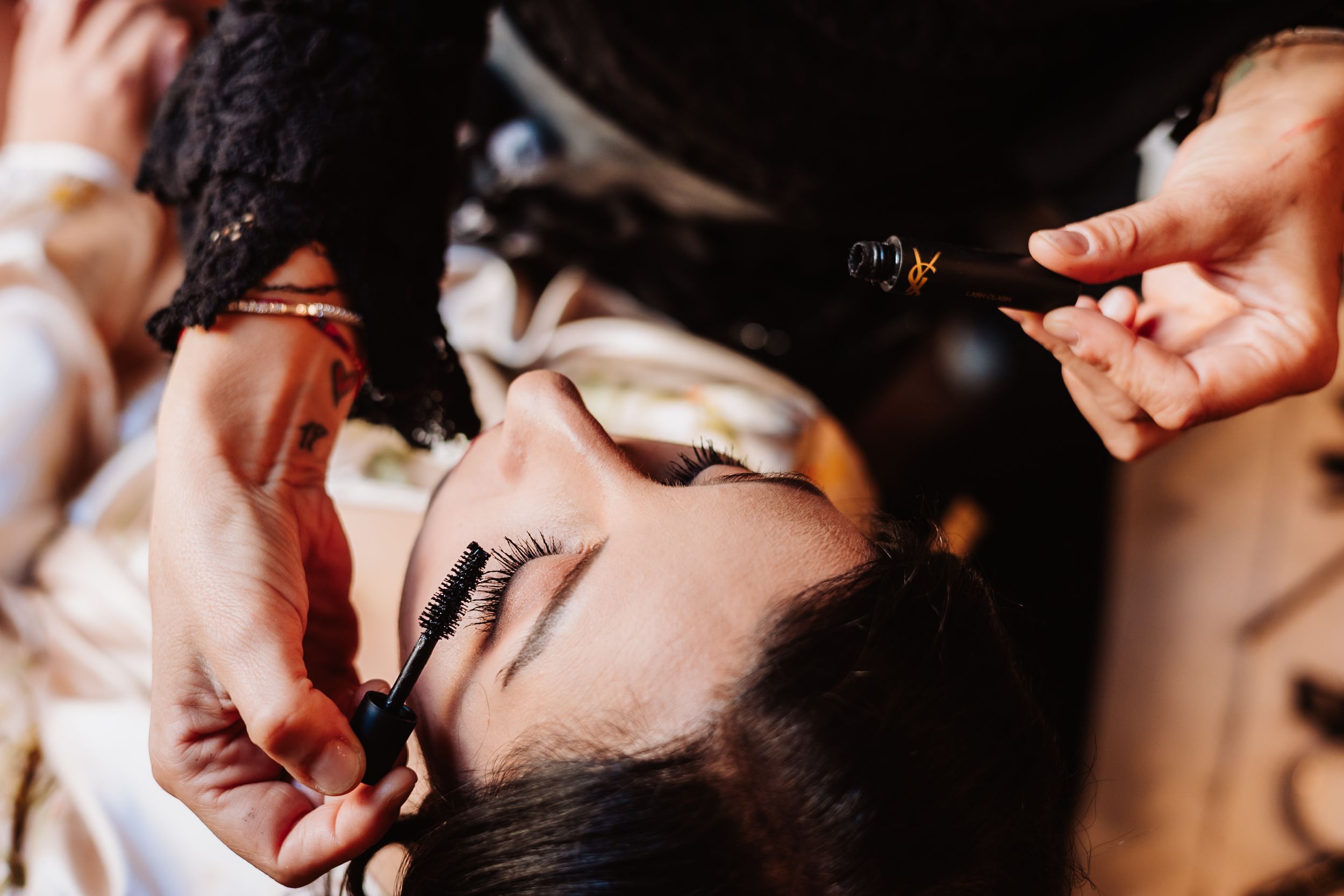 Close-up shot of someone getting their eye makeup professionally applied with a brush.
