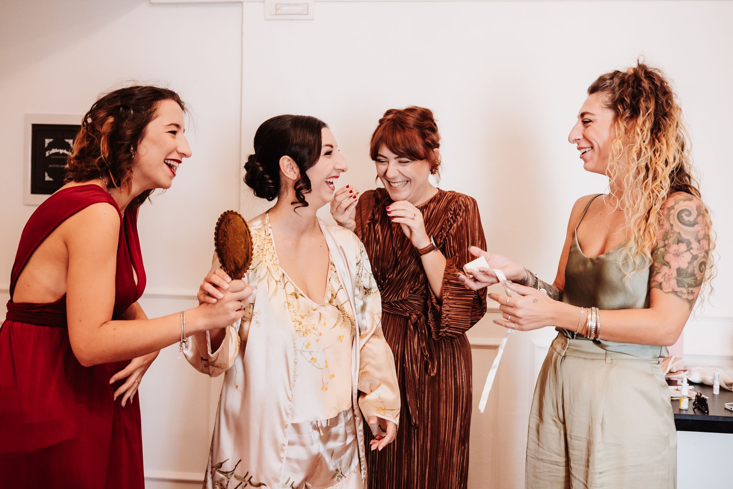 A group of people in formal attire laugh and share joyful moments together at a celebration event.