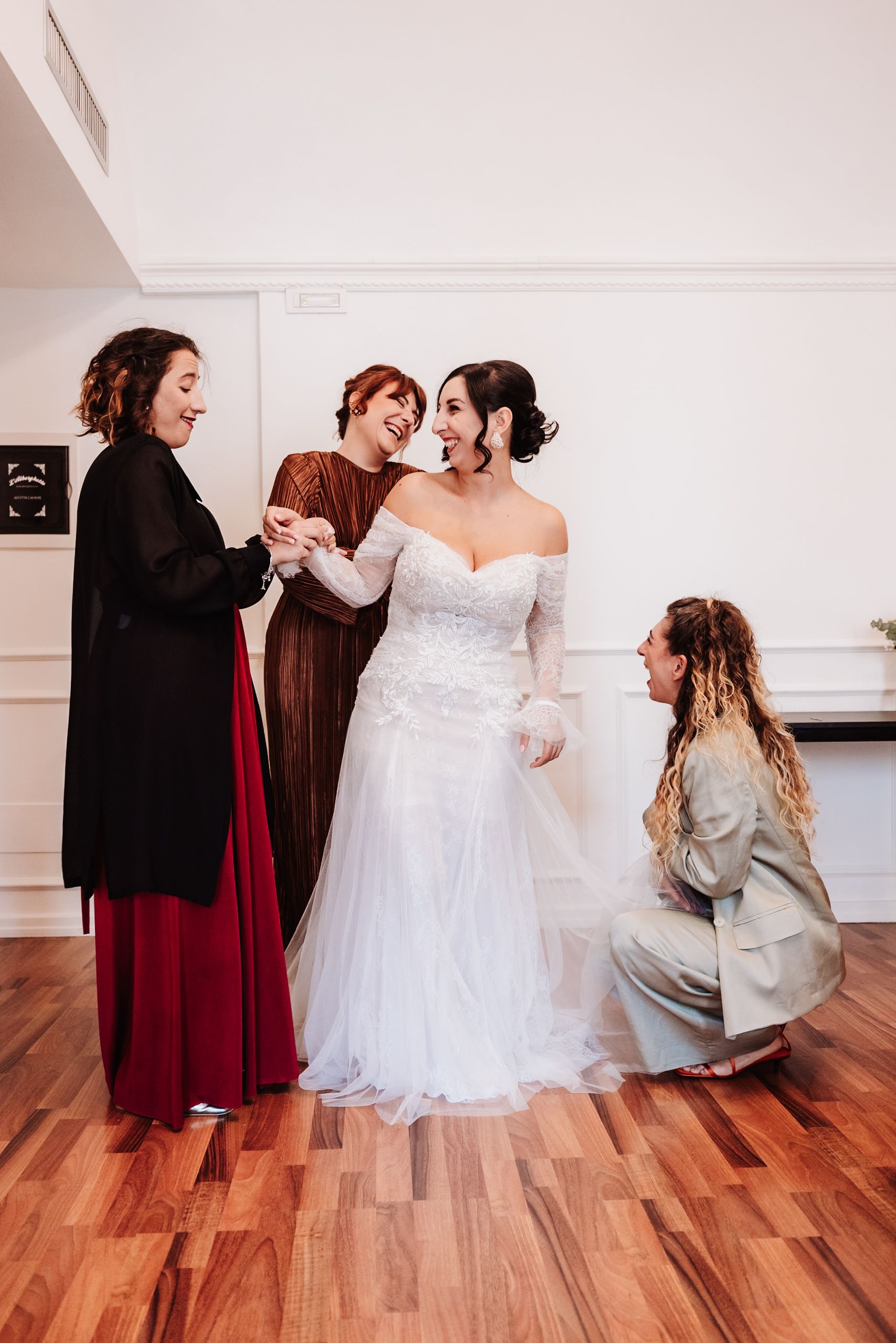 A sequence of photos showing bridesmaids helping adjust a white wedding dress on a wooden floor.