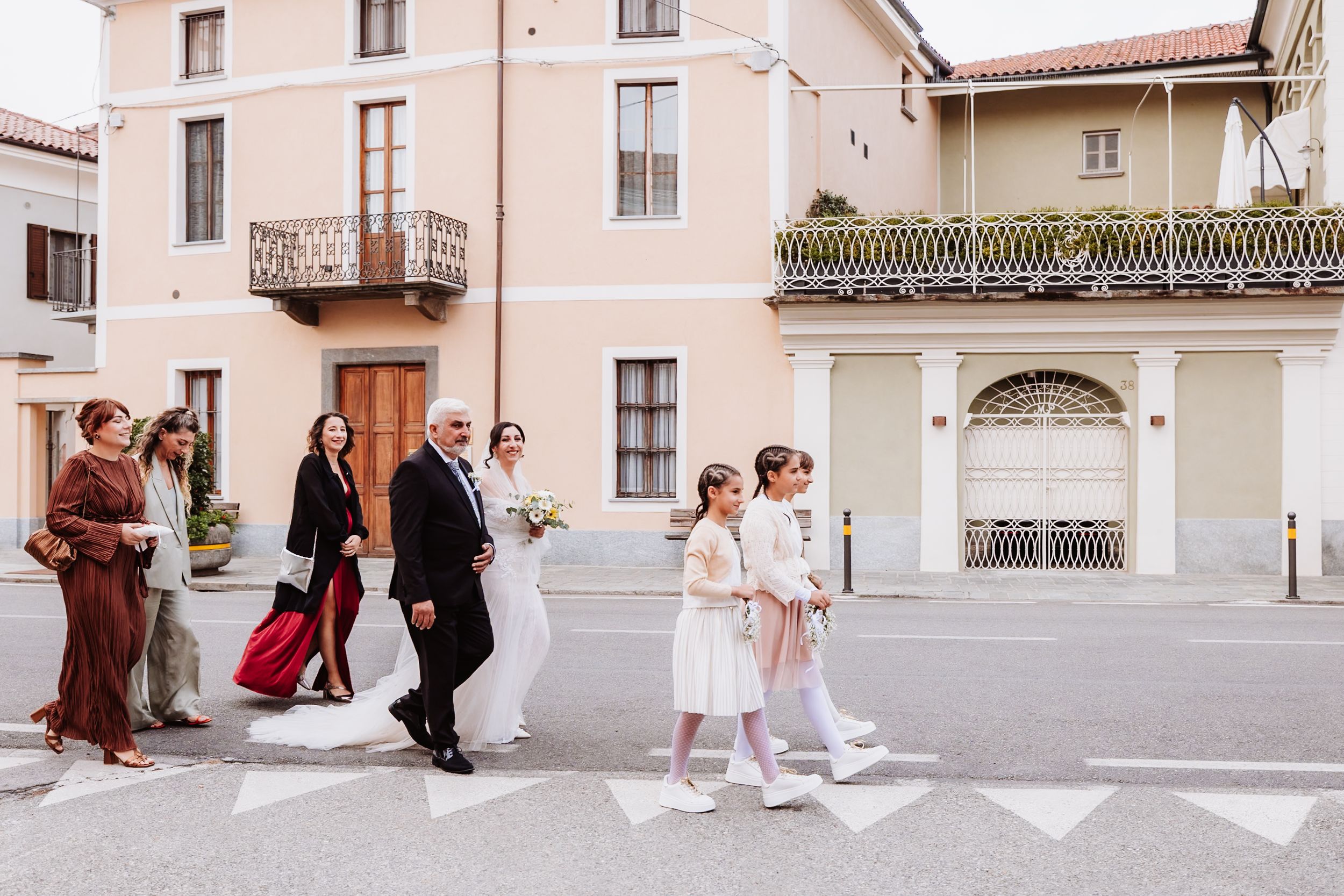 A series of connected photos showing wedding party members walking and posing on a Mediterranean-style villa terrace.