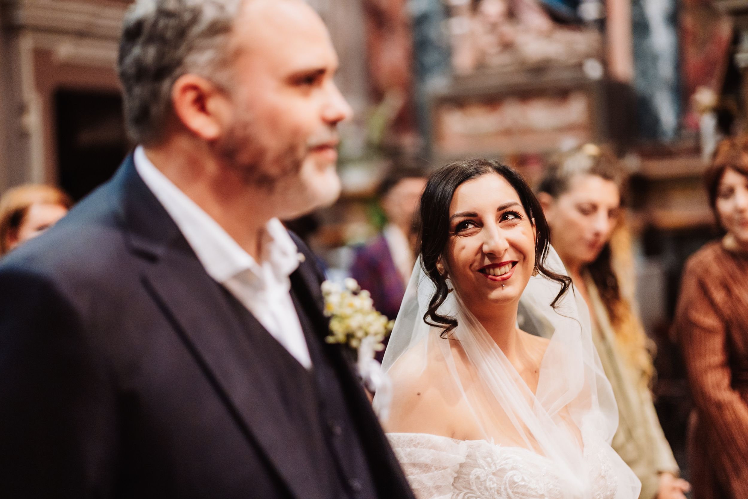 A candid wedding celebration moment captured in a warm rustic setting showing joyful expressions and interactions.