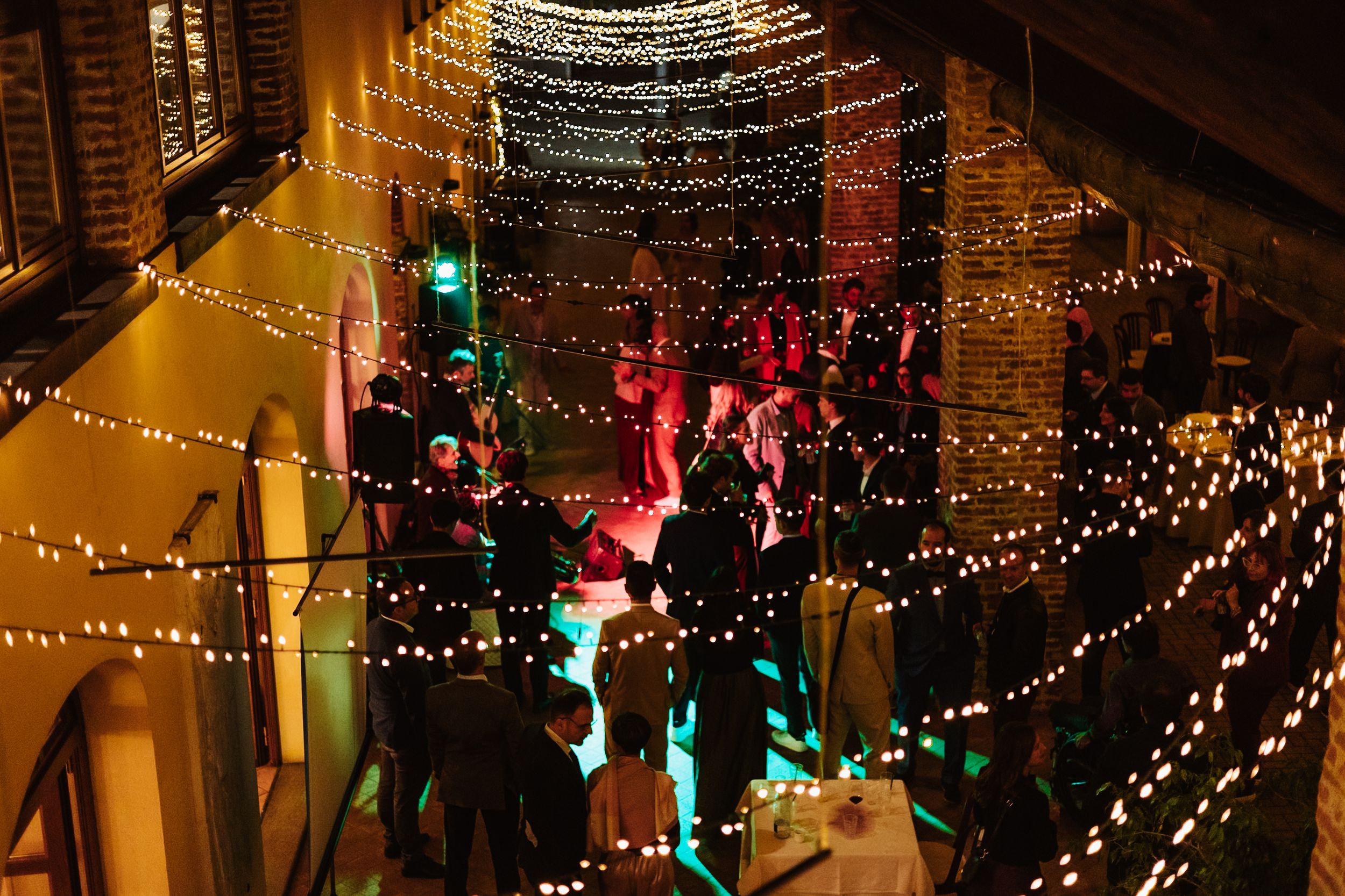 Decorative string lights create a warm, festive ambiance across an outdoor patio ceiling at night.