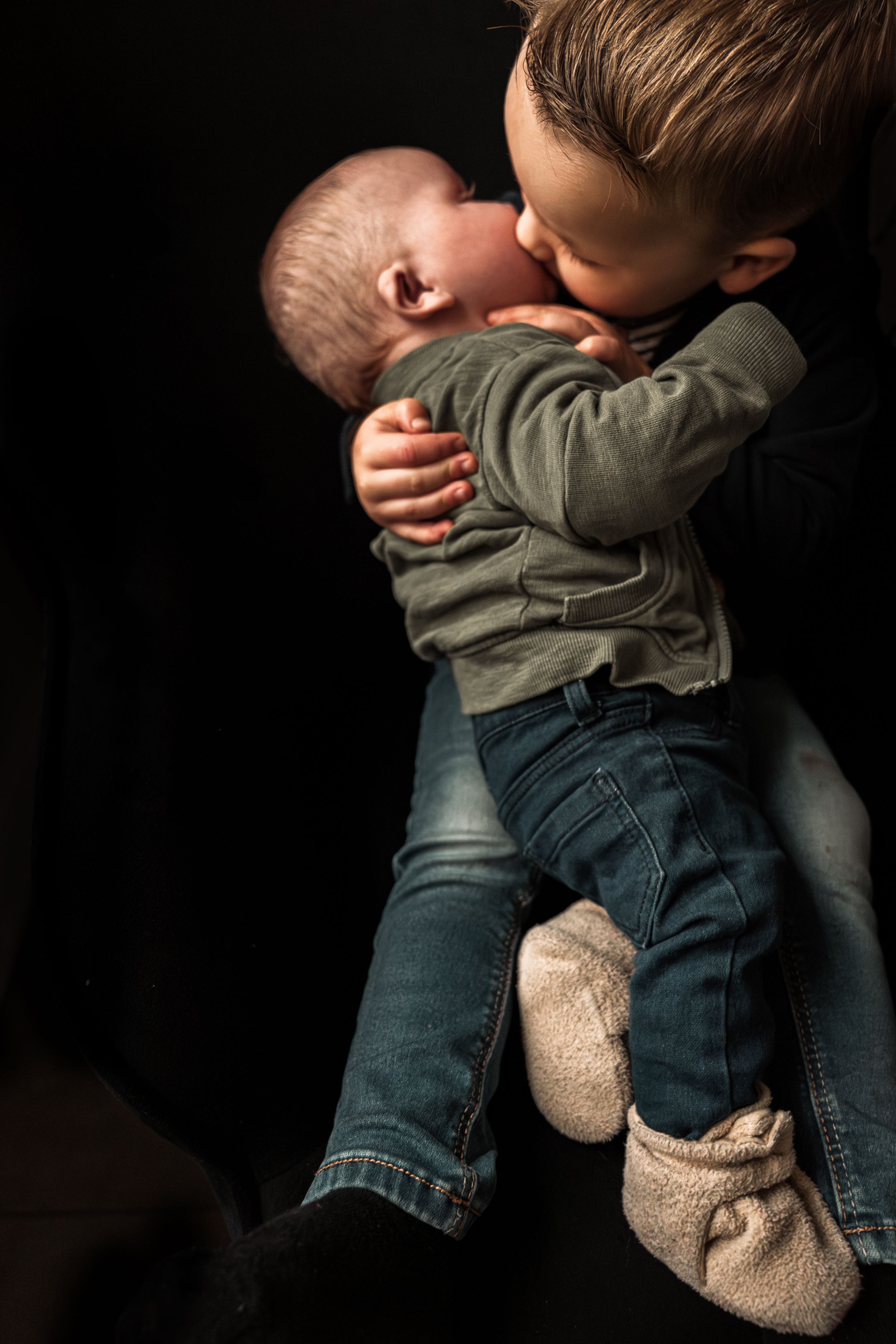 A sequence of photos showing a person in jeans holding and embracing a teddy bear against a dark background.
