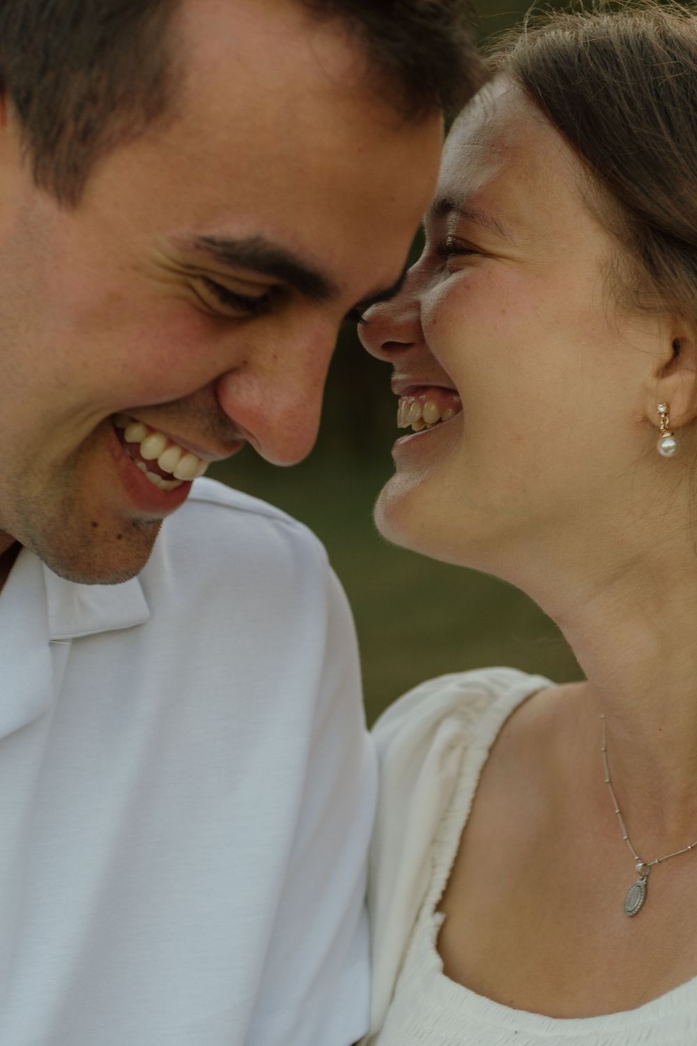 Romantic close-up portrait of couple sharing an intimate moment against blurred natural background.
