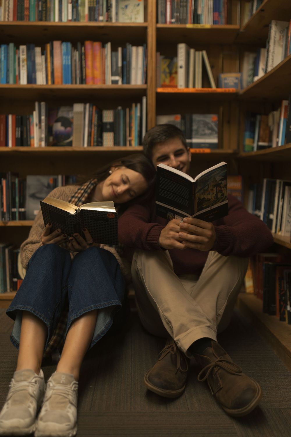 Four side-by-side photos showing feet and legs of people reading books while sitting on the floor of a library.