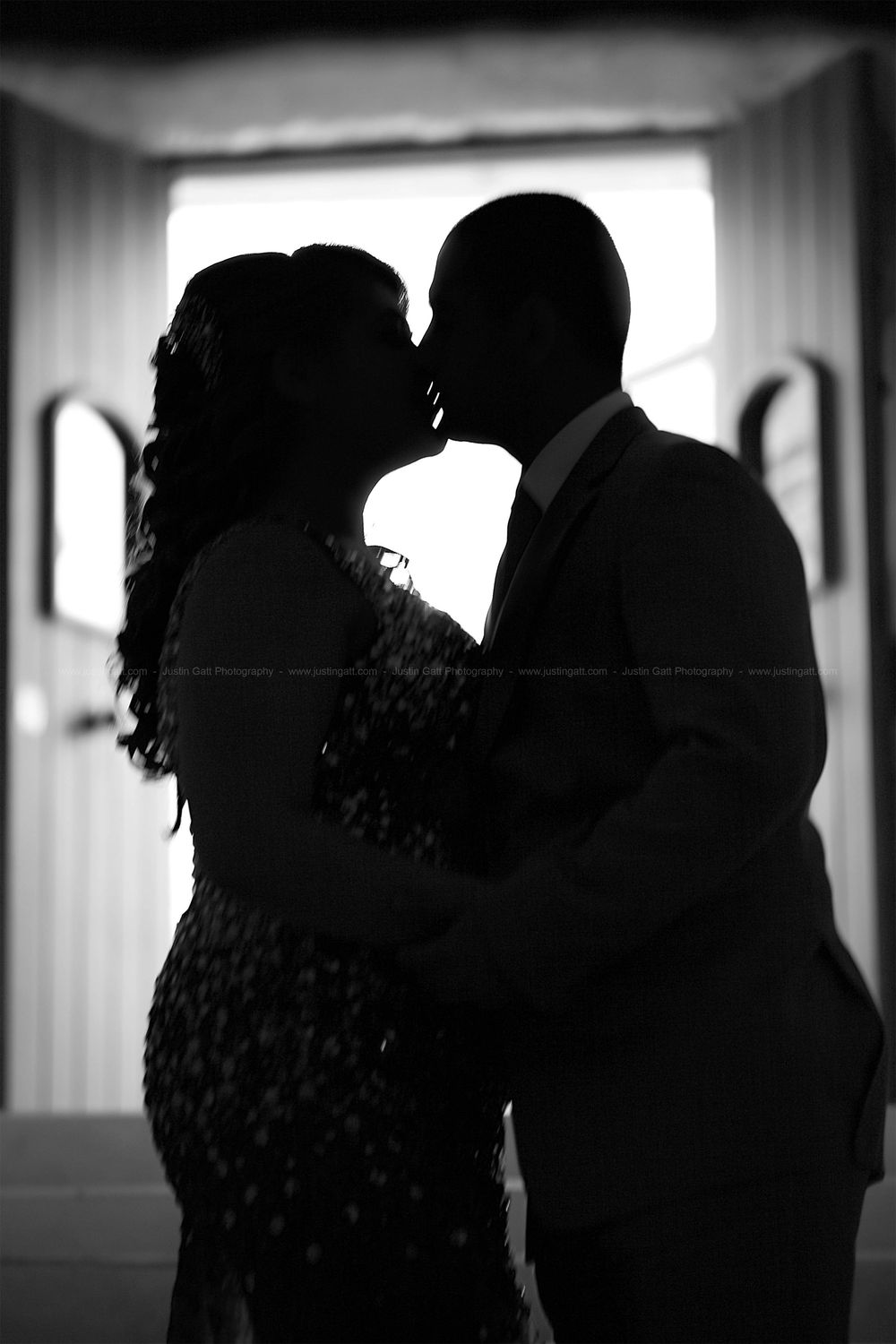 Silhouetted couple dancing in dramatic black and white lighting.