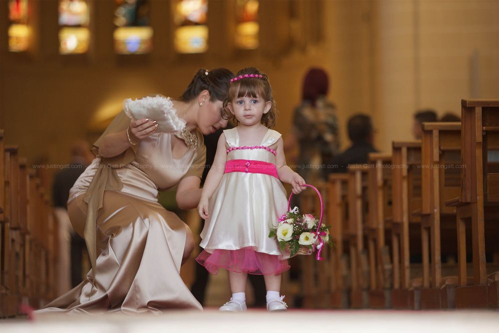 A tender moment shared between two figures in formal attire inside a church with wooden pews.