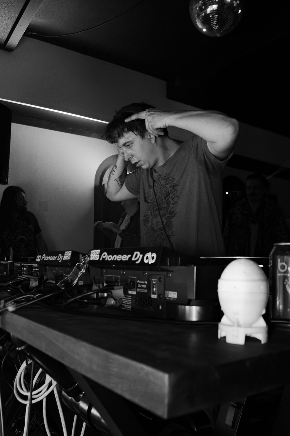 Pioneer DJ equipment setup on a dark counter with minimal lighting in a club environment.
