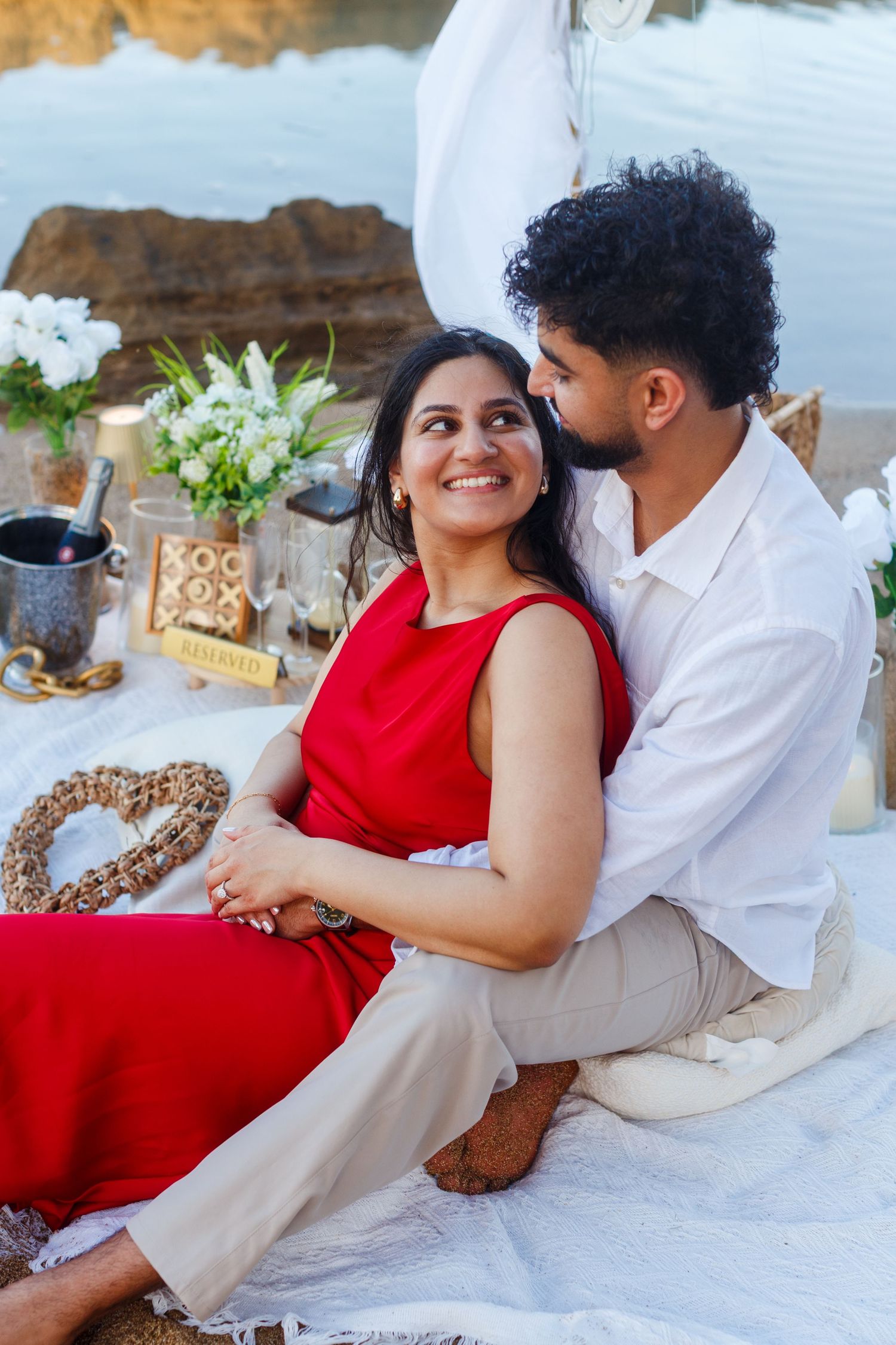 Couples portrait. Proposal and engagement session. Man and woman seated on the beach.  Kikita Surf Beach, Dorado, Puerto Rico.