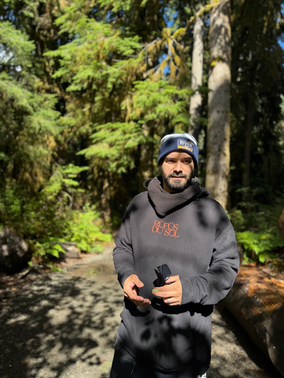Photographer standing in a forested outdoor location during a destination wedding photoshoot