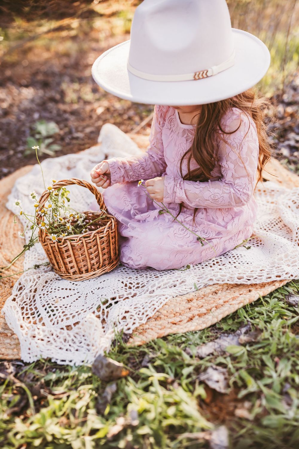 A collection of vintage-inspired photos featuring pink dresses, white hats, and wicker baskets on lace blankets outdoors.
