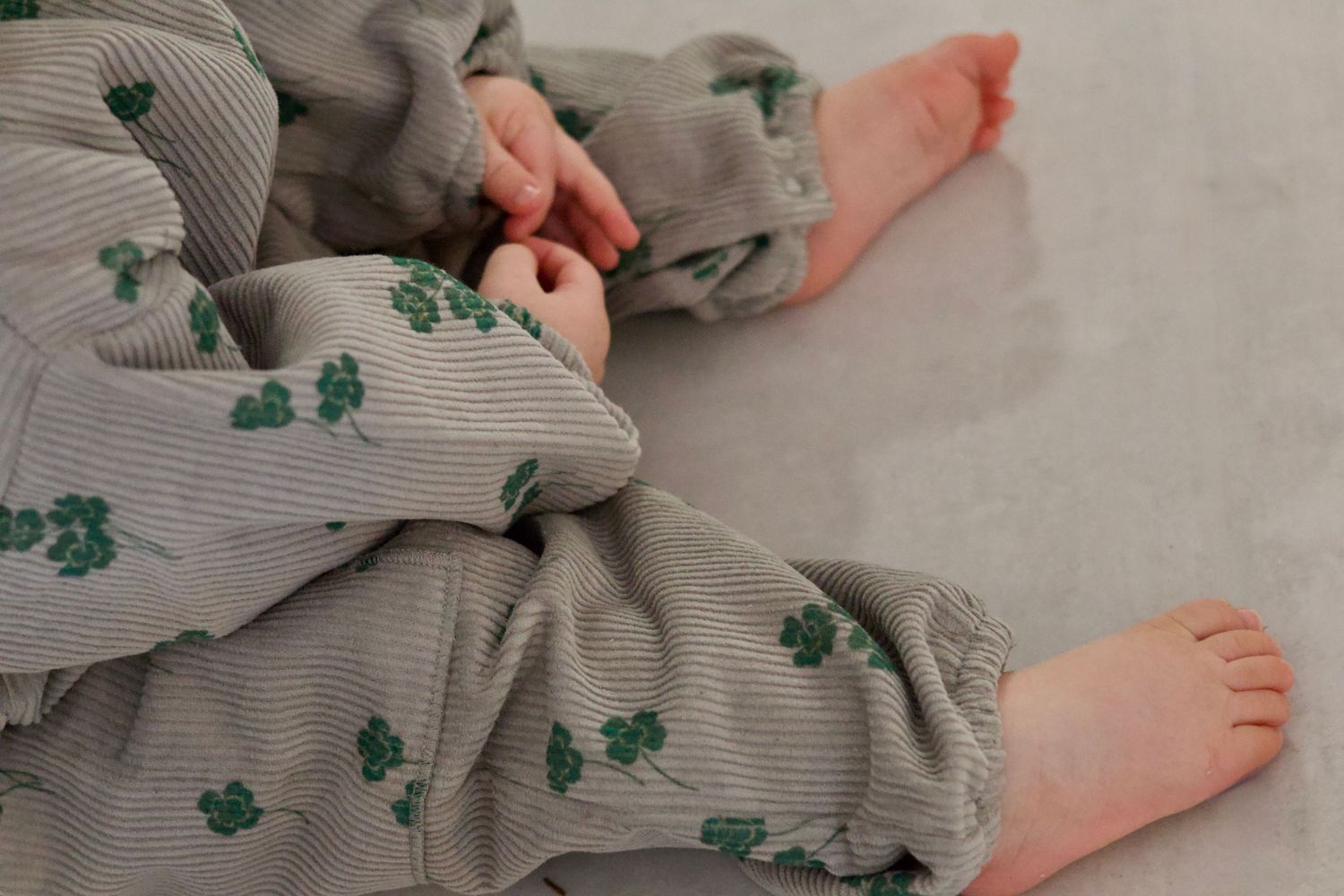 Petits pieds et mains de bébé capturés dans un moment naturel pendant une séance photo bébé en lumière douce par WA Visuel photographe à Aub
