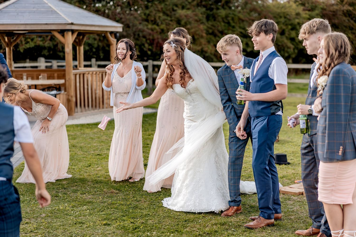Documentary wedding photography of a bride playing with wedding guests.