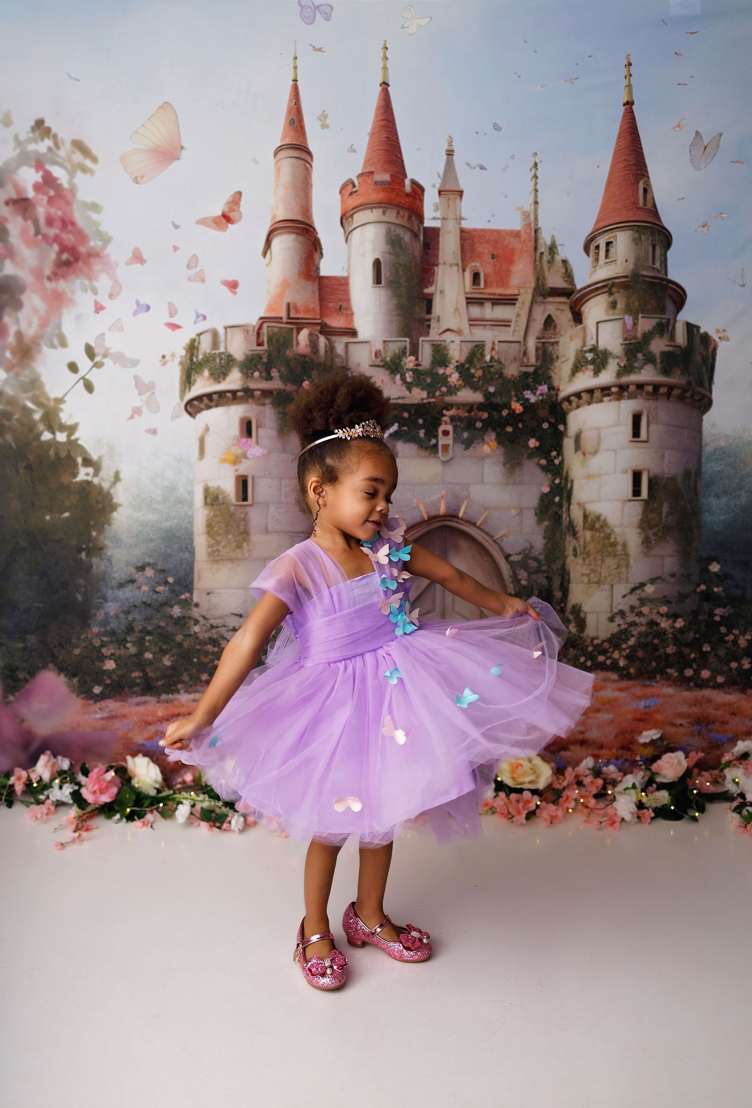 A magical princess photo session featuring a twirling purple tulle dress against a dreamy castle backdrop.