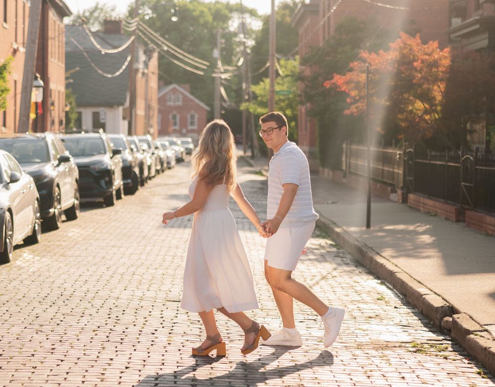 Couple walking hand in hand down a cobblestone  German Village Columbus Ohio Engagement Session