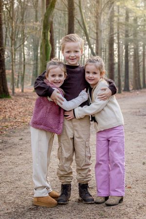 Grote broer met tweelingzusjes tijdens een fotoshoot op de Lemelerberg