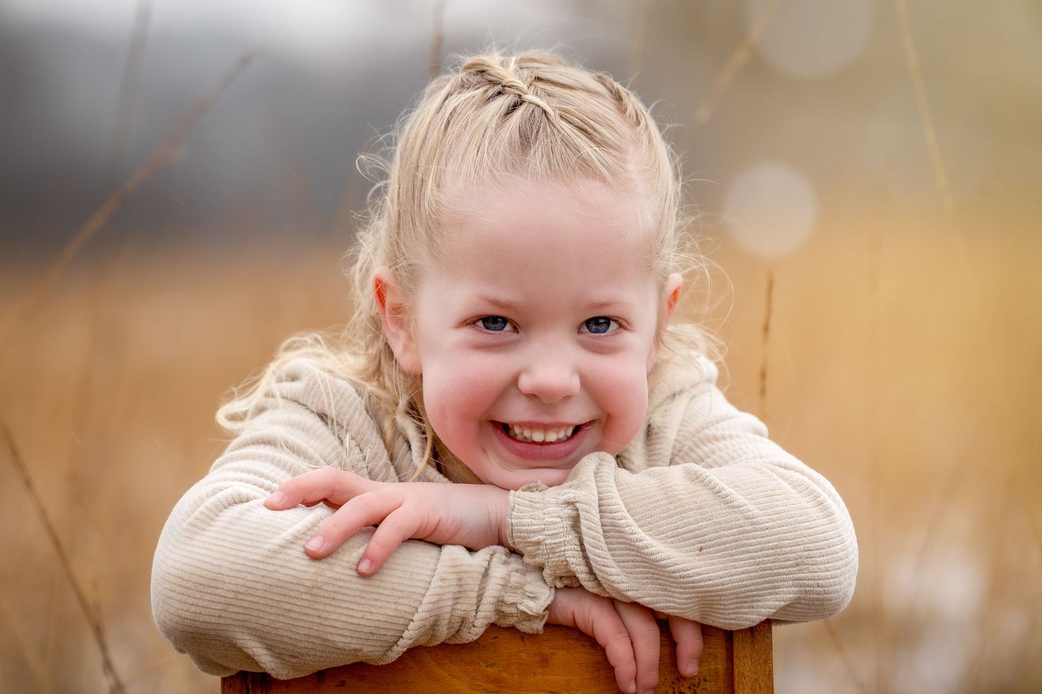 portret van een jong meisje, achterste voren zittend op een stoel