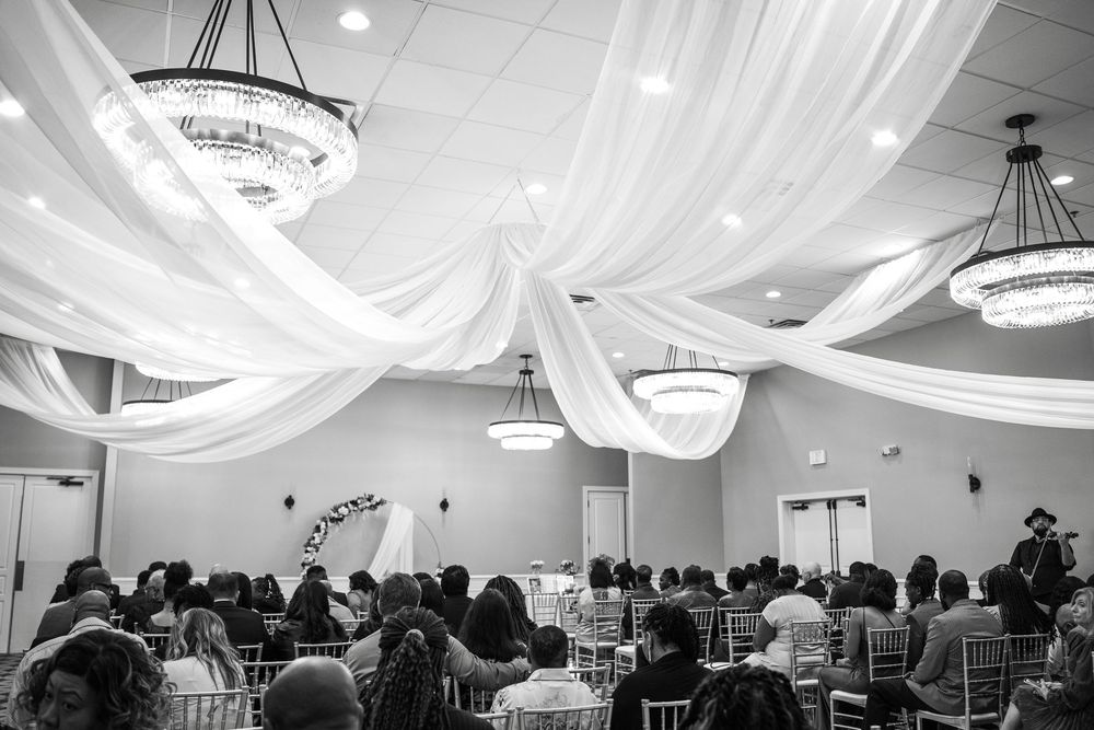 Wedding reception venue with white fabric draping and elegant chandeliers creating a romantic atmosphere at Carollwood Country Club in Tampa