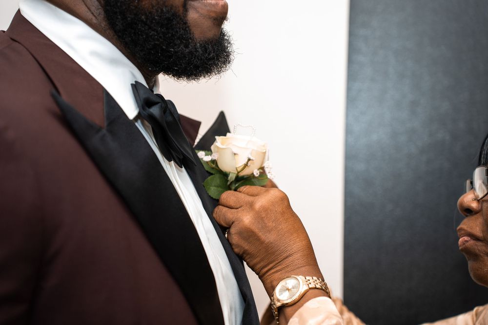 A person in a tuxedo adjusts their bowtie in a series of close-up shots against a dark background at Carollwood Country Club in Tampa, Flori