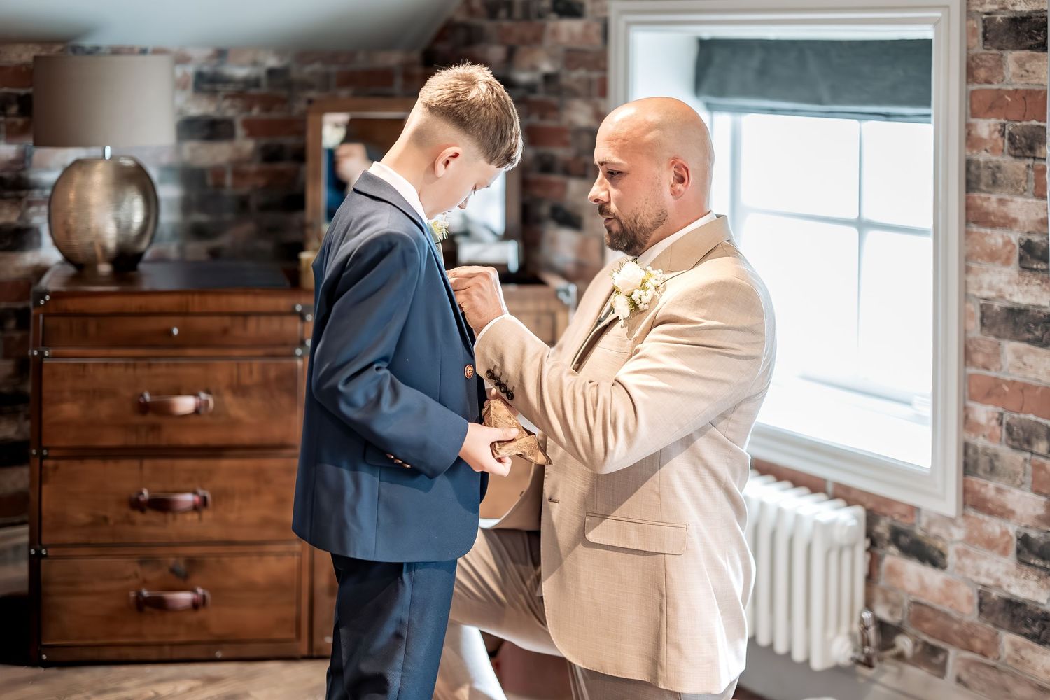 Unobtrusive wedding moment between father and son.