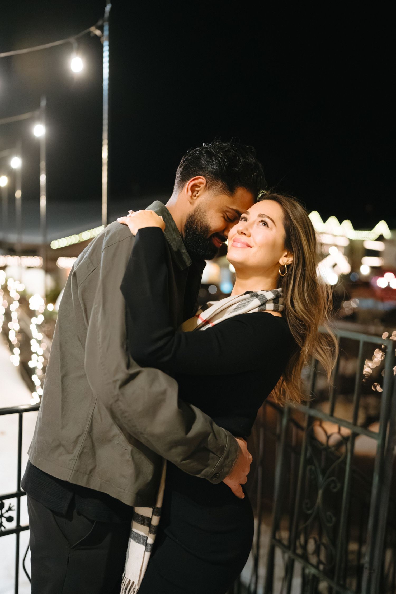 Intimate nighttime portrait session with string lights creating a romantic ambiance.