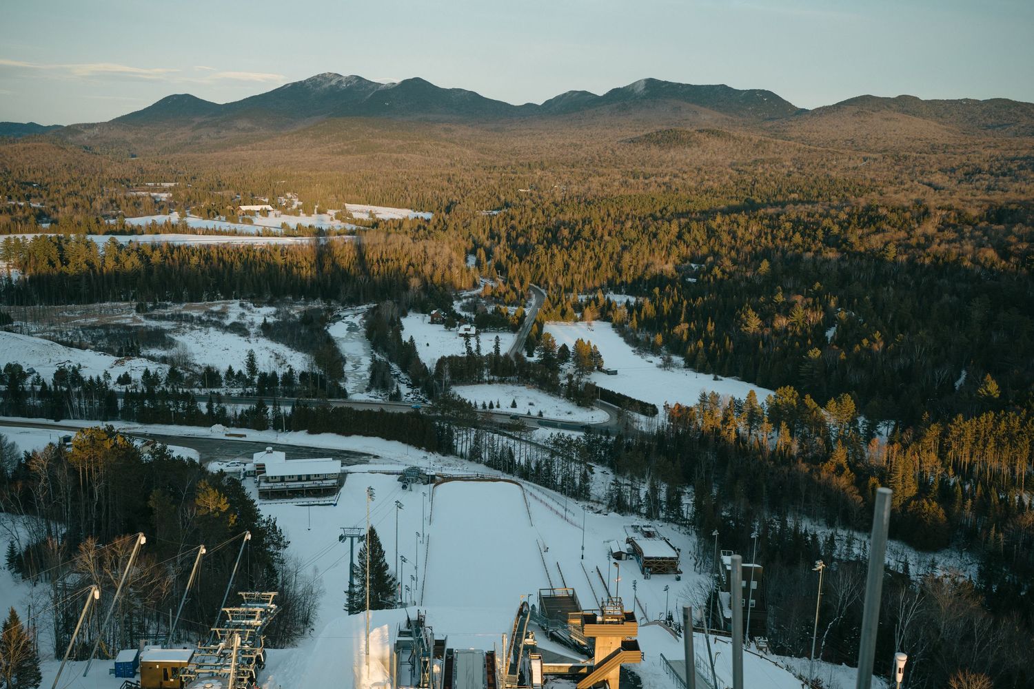 Snow-covered ski slopes and mountain terrain with evergreen forests stretching across a winter landscape.