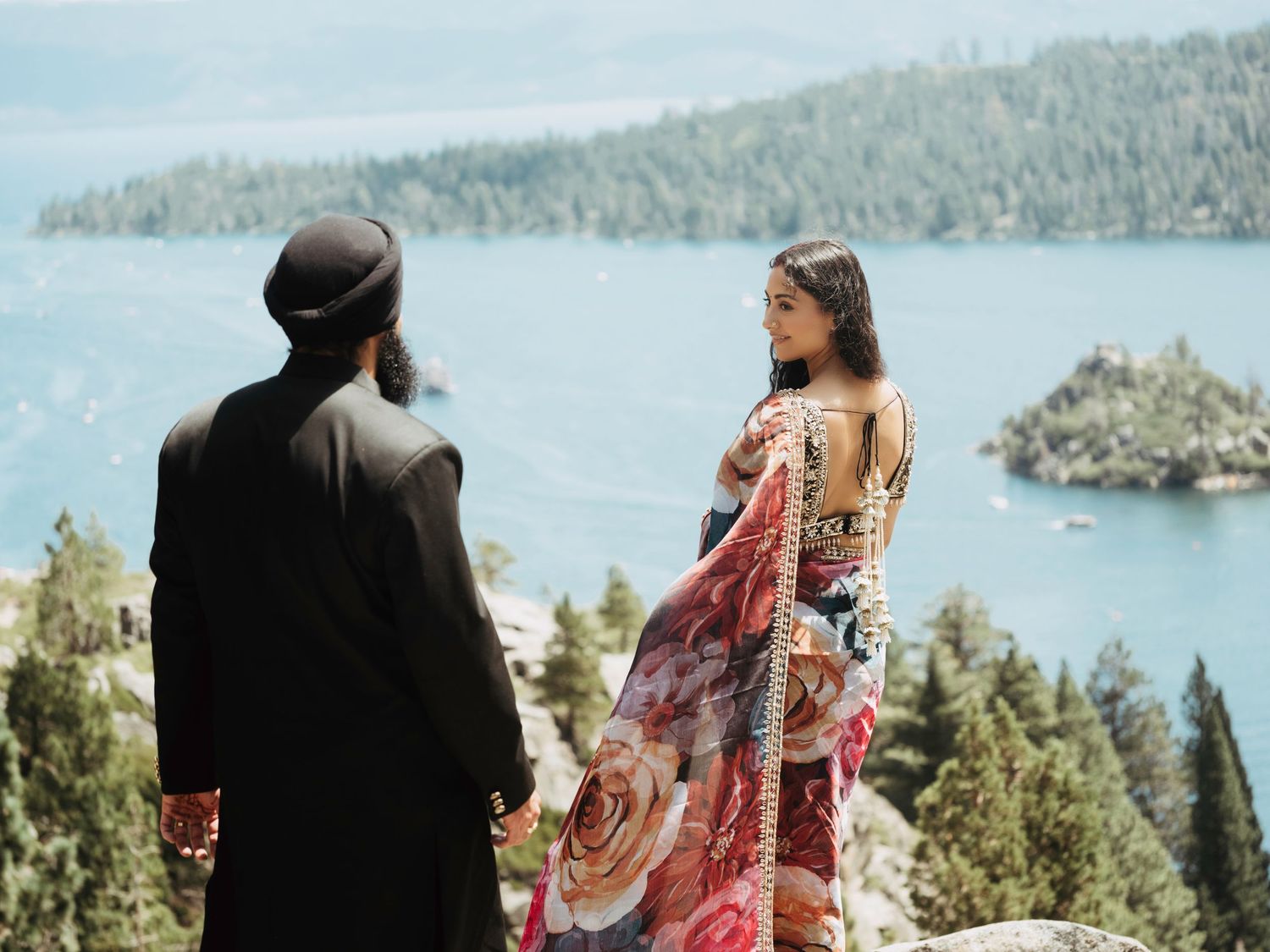 Couple enjoying a picturesque picnic overlooking a scenic mountain lake surrounded by evergreen forests.