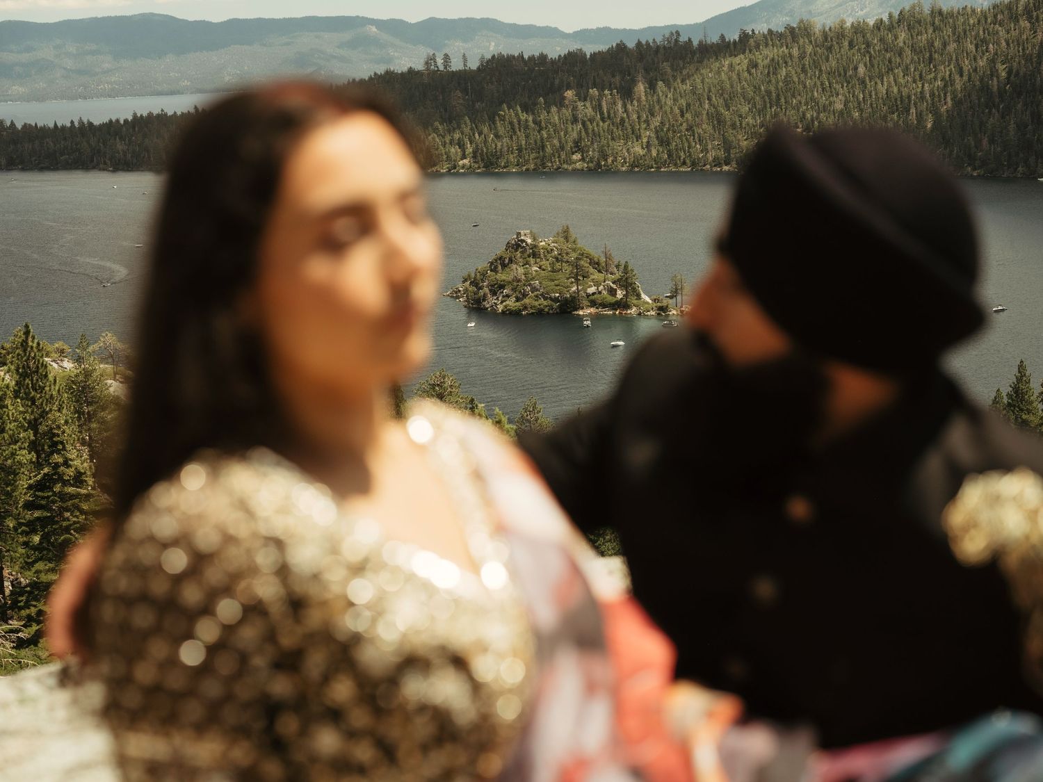 Romantic lakeside picnic setup on a rocky overlook with mountains and pine trees in the background.