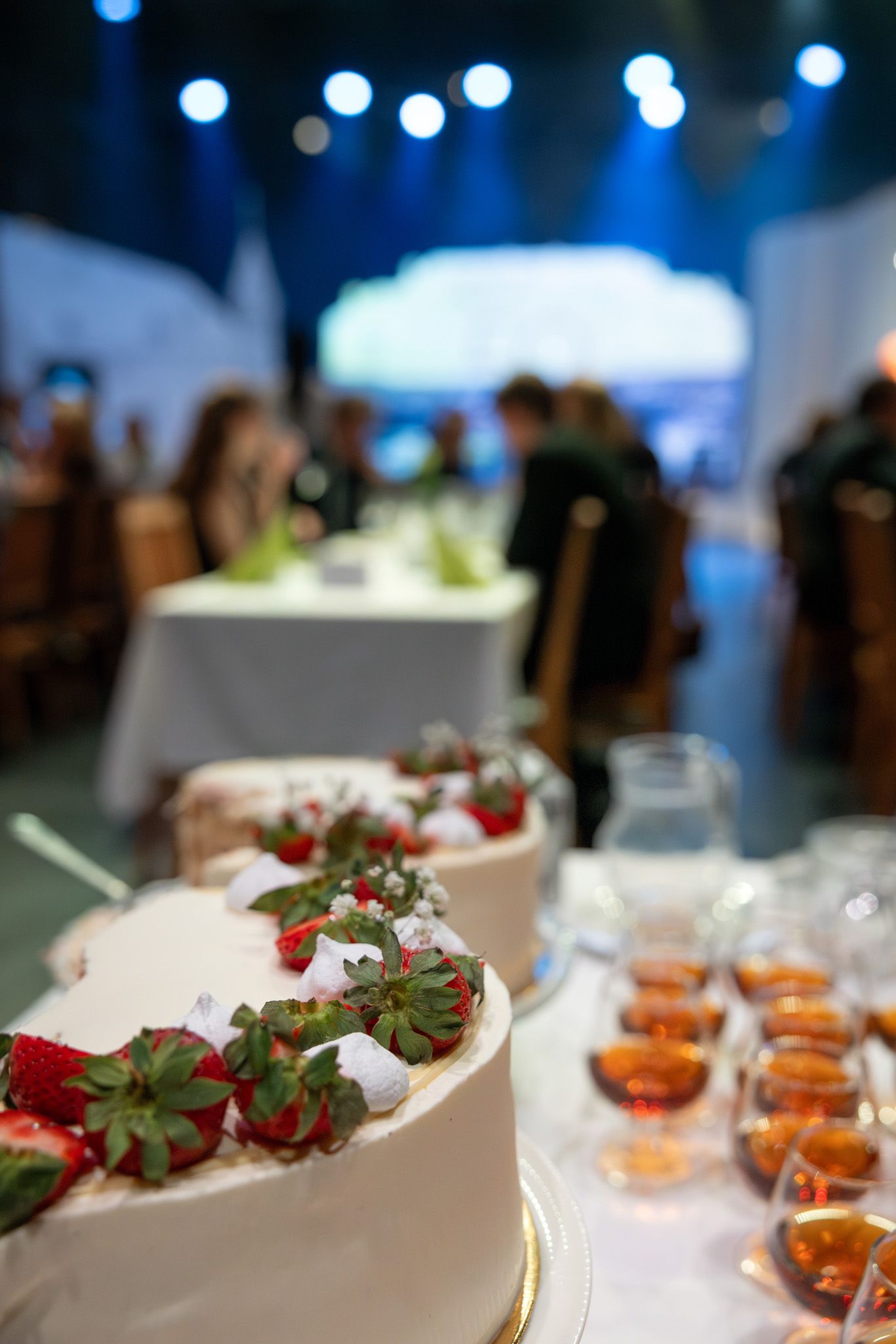 Elegant dessert display featuring chocolate covered strawberries and small appetizers on white serving platters.