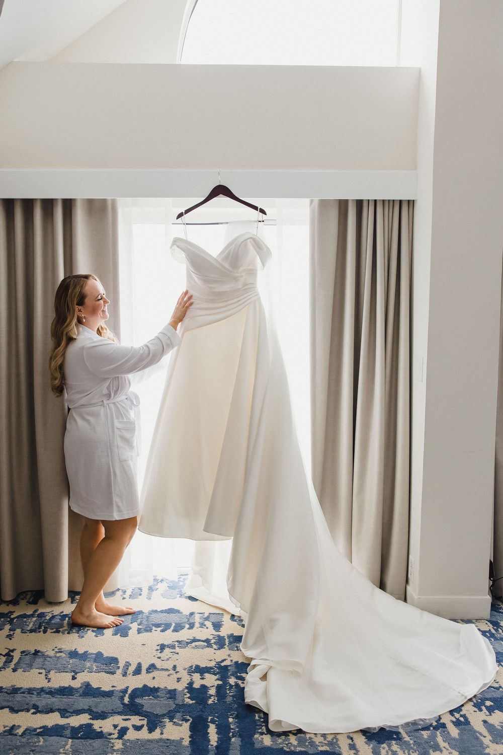 A series of photos showing someone in a white robe reaching up to hang a wedding dress on display.