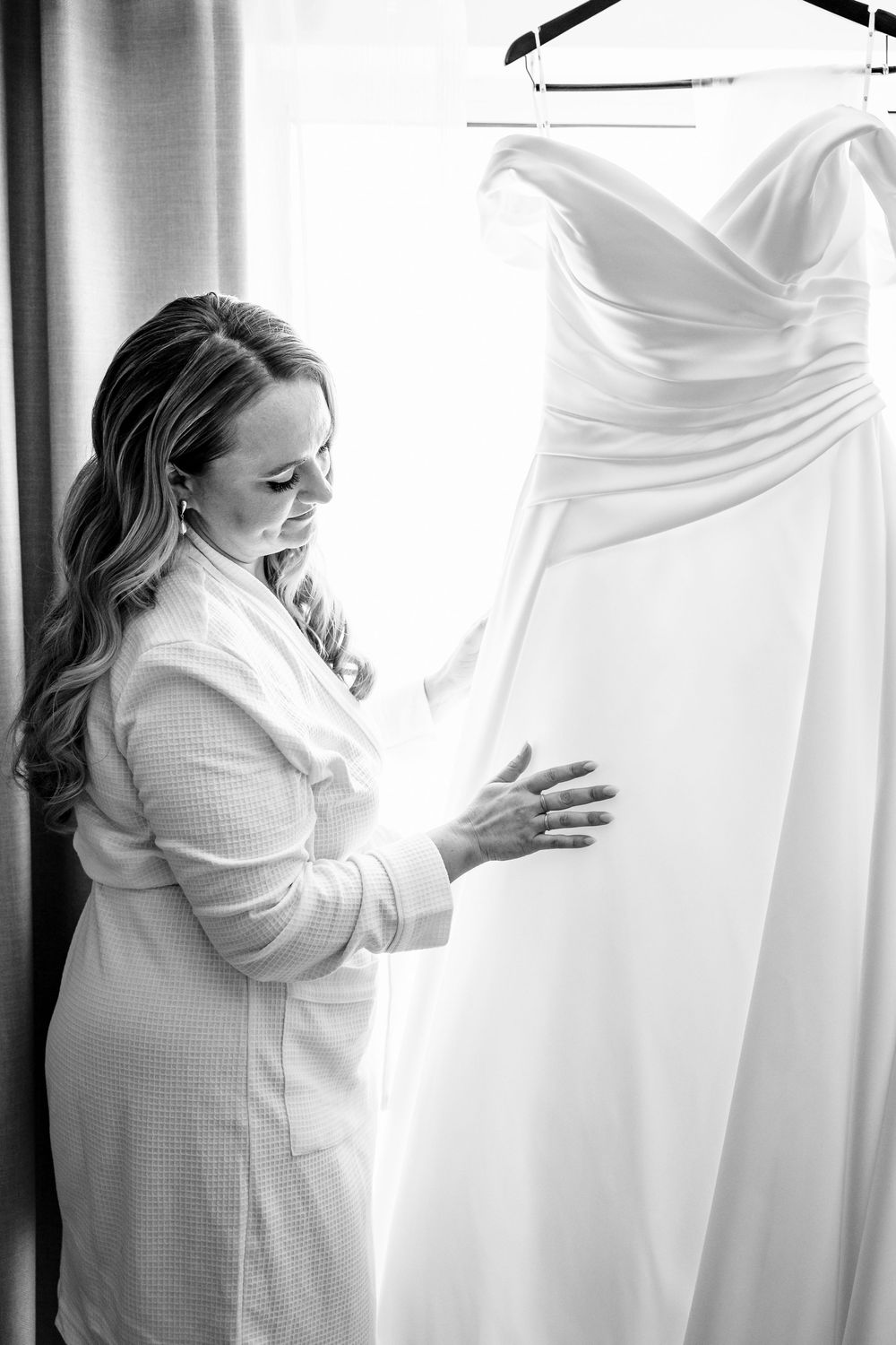 A series of black and white photos showing a person in white clothing hugging what appears to be a wedding dress.