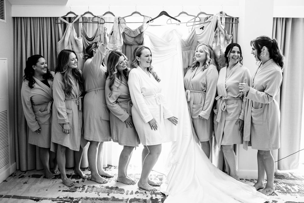 Wedding party lined up in matching grey dresses against a white background.