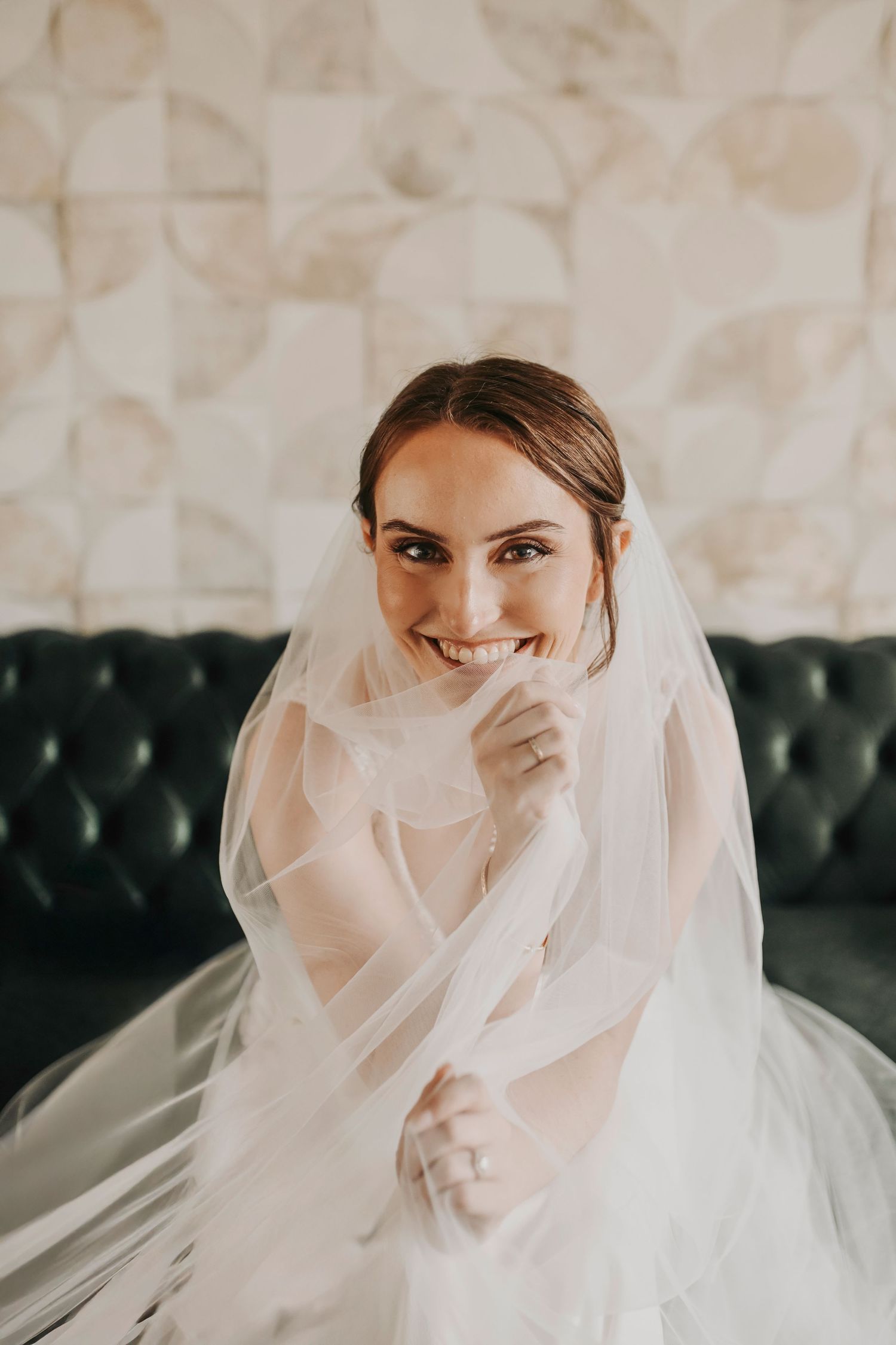 Beautiful Dallas bride smiling while getting ready with bridesmaids in the bridal suite before the ceremony.