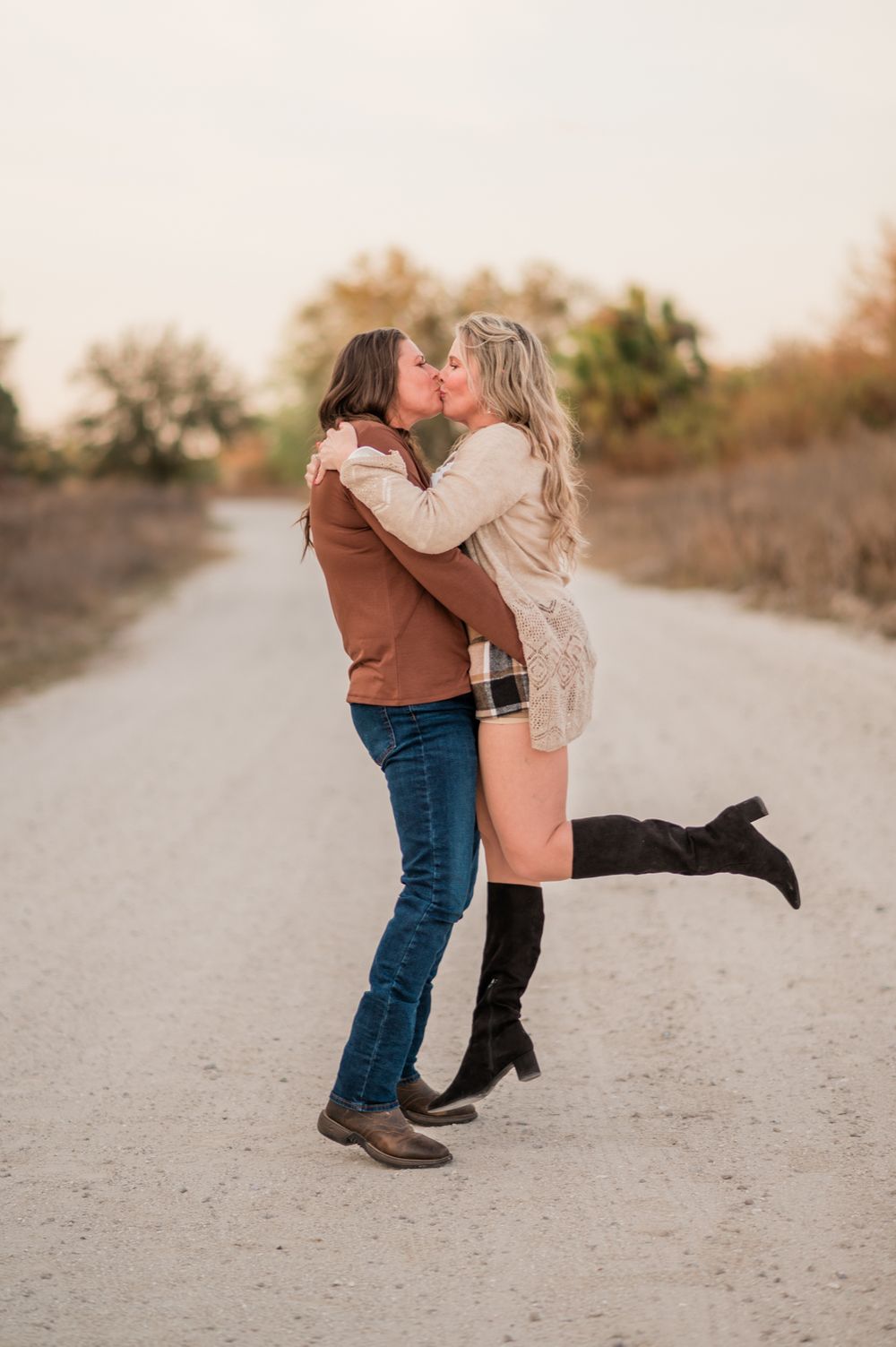 Candid shots show two people hugging and playing on a sandy path at sunset.
