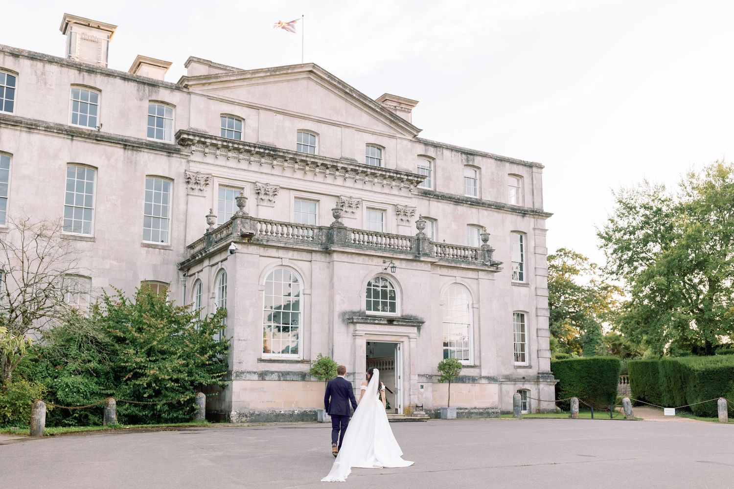 Bride and Groom walking up to Kingston Maurward House, photographed by Maddie Waters Hampshire wedding photographer