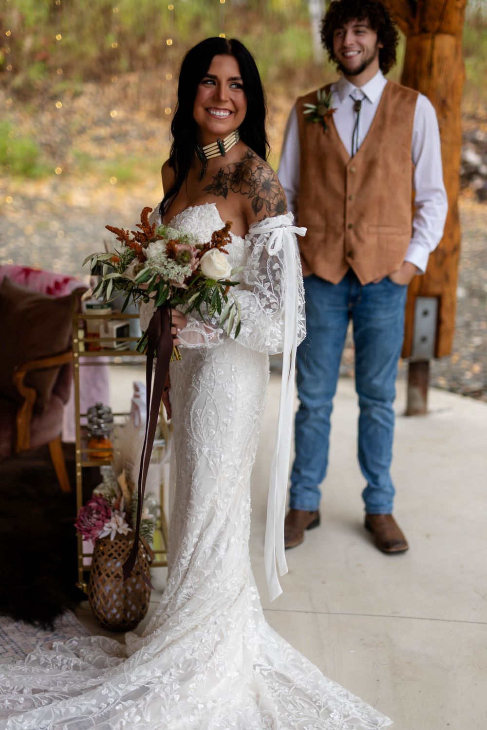 A wedding portrait featuring bohemian style attire in a rustic outdoor setting.